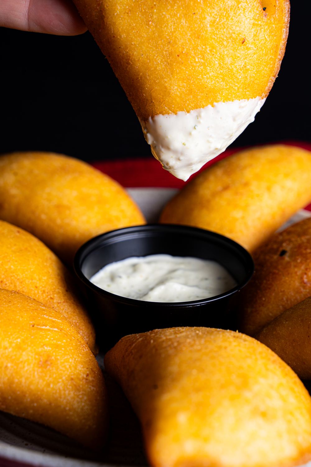 Empanada bañada en salsa de ajo con más empanadas alrededor