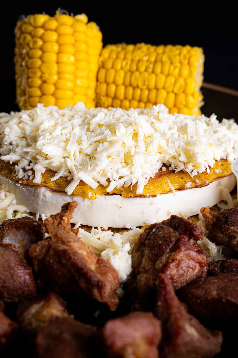 Cachapa con queso rallado, maíz y carne frita