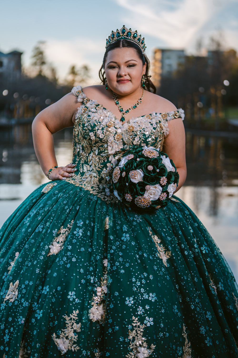 Quinceañera con vestido verde y ramo de rosas